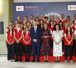 Fotografía de grupo de Su Majestad la Reina junto a un grupo de voluntarios de la Cruz Roja Española (CRE)